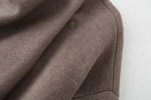 Macro view of dark brown knitted fabric showing detailed fiber texture and stitching