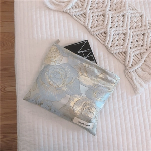 Detail of rose jacquard cosmetic bag with golden metallic threads and zipper design
