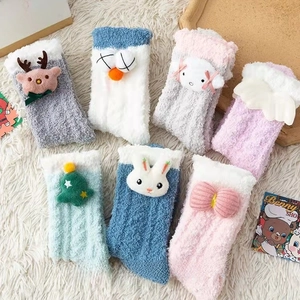 Vue à plat de chaussettes en molleton corail avec d'adorables peluches 3D de dessin animé