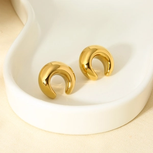Polished 16K gold plated stainless steel C-shape hoop earrings on a minimalist tray