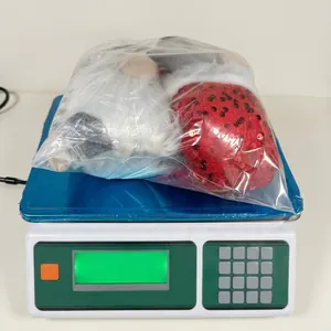 Detailed view of a Christmas gnome plush with sequined red hat in protective packaging