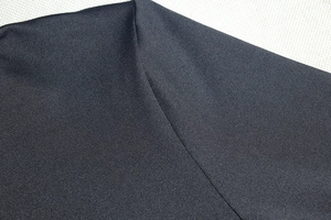 Detailed macro view of dark navy knit fabric texture and high-quality stitching on dress