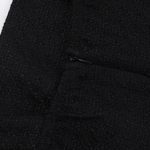 Macro shot of invisible zipper and textured black tweed fabric on a stylish dress