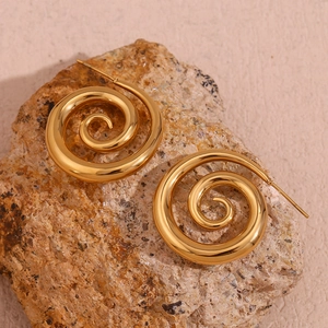 Macro detail of 18K gold plated spiral earrings on a natural light brown stone background