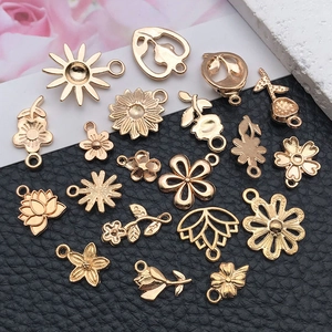 Detailed view of KC gold flower pendants including sunflower and rose for DIY jewelry