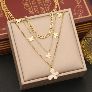Three-layer gold butterfly necklace with white shell pendant on jewelry box