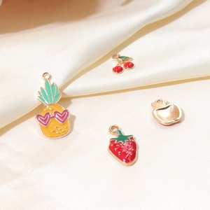 Detail of DIY fruit pendants including strawberry and pineapple shapes in gold metal