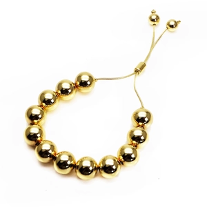 Detail of adjustable gold beaded bracelet featuring 4mm high polished metal round beads