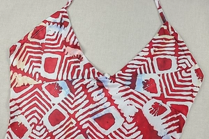 Close-up of red and white geometric wave print on the halter neckline of the summer dress