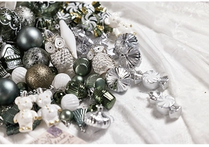 Dettaglio di addobbi natalizi argento e verde scuro in varie forme festive e decorati