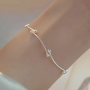 Minimalist silver beaded knot bracelet for women shown on wrist in a lifestyle view