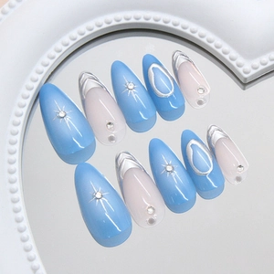 Blue and white almond press-on nails with silver starburst patterns and rhinestones