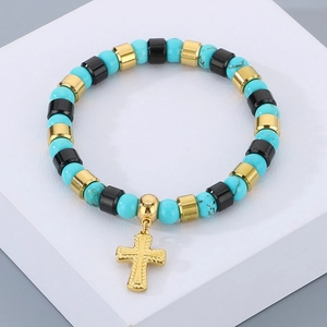 Détail de perles turquoise colorées avec un pendentif croix en acier doré sur bracelet