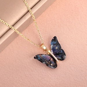 Close-up of butterfly pendant with starry blue gradient finish and sparkling crystals