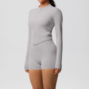 Detail of light grey slim-fit yoga set featuring zip-up long sleeve and high waist shorts