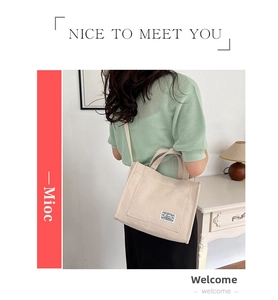 Beige corduroy tote bag detail showing shoulder strap and compact square design