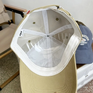 Detail view of khaki cotton baseball cap interior with stitching and sweatband