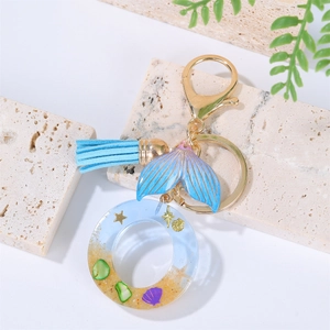 Detail of blue gradient mermaid tail keychain with resin shell pendant and tassel