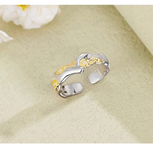 Detail of 925 sterling silver lava texture ring with gold contrast and inlaid zircons