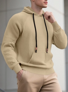 Nahaufnahme des beigefarbenen Herrenkapuzenpullovers mit grobem Strickmuster und Jacquard