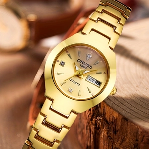 Détail macro d'une montre dorée pour femme avec cadran soleil et guichet jour-date