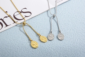 Detail of adjustable gold and silver snake chains with oval Virgin Mary relief pendants