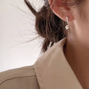 Elegant 925 sterling silver irregular curved earrings with white round pearls on model