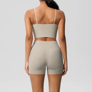 Detail view of almond beige backless yoga set featuring strappy top and high waist shorts