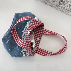 Détail du sac en denim avec poignée à carreaux rouges et bordure en dentelle blanche