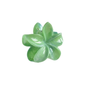 Macro detail of mint green plumeria flower hair claw clip with marble resin texture