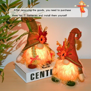 Detail showing two light-up harvest gnomes with warm LED glow and orange fabric hats