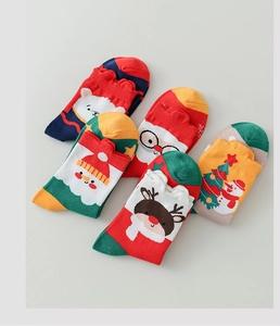 Detailed view of knitted cotton Christmas socks featuring reindeer and Santa Claus patterns