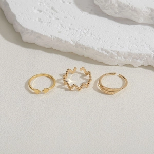 Three-piece gold adjustable ring set featuring star, wave, and feather designs