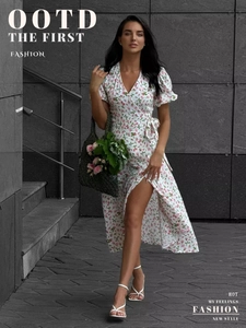 Detail of white wrap dress with pink floral print, V-neckline and puff sleeves on a model