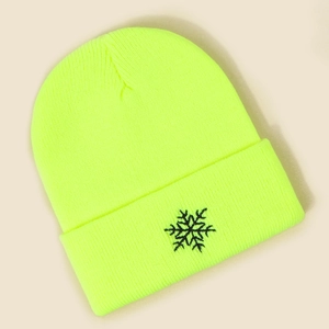 Vue détaillée du bonnet en tricot jaune fluo avec une broderie de flocon noir