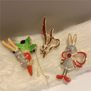 Detail of golden rabbit hair claws with red enamel, pearls and dangling tassels