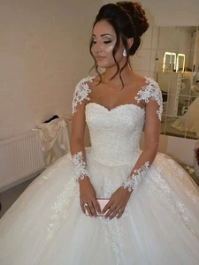Détail d'une robe de mariée avec encolure en cœur perlée et appliqués floraux en dentelle