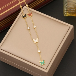 Détail du collier papillon doré avec pendentifs multicolores sur une boîte à bijoux