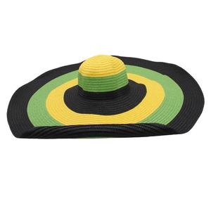 Detail of oversized straw sun hat with black yellow and green stripes in reggae style