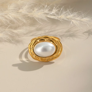 Close-up of 18K gold plated vintage pearl ring with an oval woven metal frame design