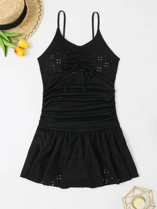 Close-up of black eyelet lace swimwear featuring a drawstring bow and pleated details