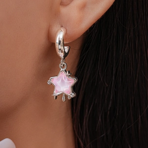 Macro shot of pink star drop earrings with silver hoops and sparkling zircon accents