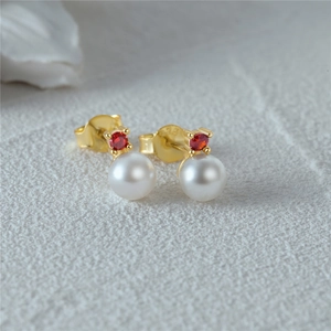 Detailed macro view of S925 sterling silver pearl earring with red round gemstone