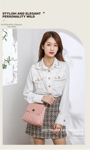Detailed view of pink quilted handbag with gold heart lock and chain strap on a model