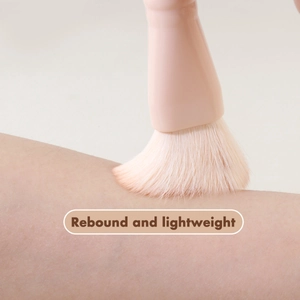 Macro shot showing high elasticity and softness of pink powder brush bristles on skin