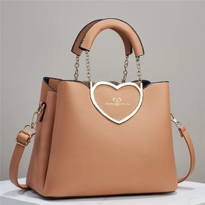 Close-up of the heart-shaped metal buckle and lychee texture on the khaki leather handbag