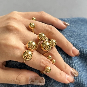 Gros plan sur une bague sphérique dorée imposante avec finition métallique polie