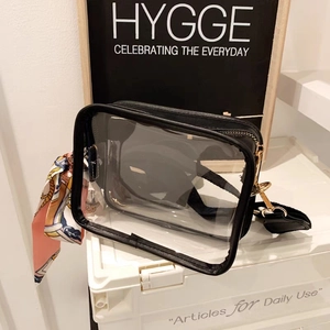 Trendy transparent PVC crossbody bag with black trim and elegant silk scarf accessory