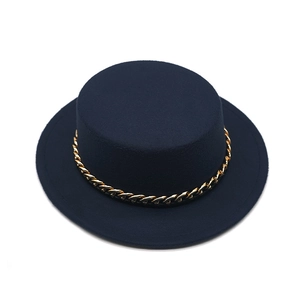 Detail of navy blue flat top wool hat with a decorative gold chain band accessory