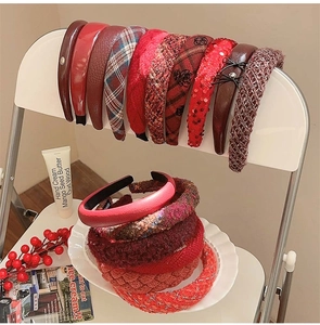 Detailed close-up of winter velvet and tweed headbands in festive red and plaid patterns
